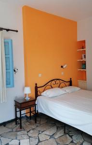 卡马利Vocamvilia Apartments的一间卧室配有一张橙色墙壁的床