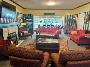 阿什兰Bayberry Inn B&B and Oregon Wellness Retreat的客厅配有红色的沙发和桌子