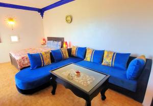 沃利迪耶Maison de la Lagune的客厅配有蓝色的沙发和桌子