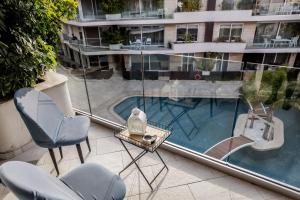 Is-SwieqiDeluxe 3BR Oasis with Pool next to beach - St Julians的一个带桌椅的阳台和一个游泳池