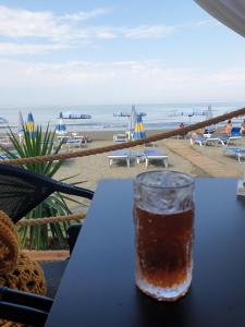 莱什Eni's Villa, 5km From Shengjini Beach的坐在海滩前的桌子上喝一杯