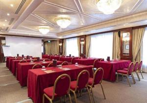 利伯维尔Hotel Impérial的一间会议室,配有红色的桌子和椅子