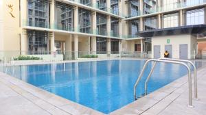 阿布扎比City Nest - 2BR apartment.的一座大型建筑,设有大型蓝色游泳池