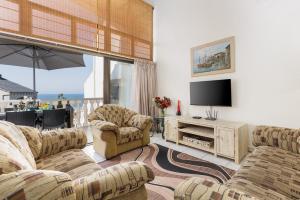 马盖特Uvongo Cabanas 15B的客厅配有2张沙发和1台平面电视