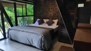 PadinjaratharaWetlands Wayanad Resort with Natural Waterfalls的一间卧室设有一张床和一个大窗户