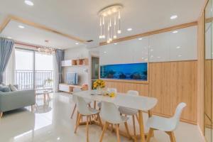 胡志明市Genius Apartment RiverGate Free Pool的一间配备有白色桌椅的用餐室