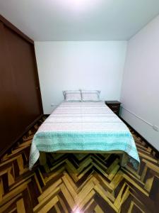 阿雷基帕Casa Vallecito的一间卧室配有一张床,铺有木地板