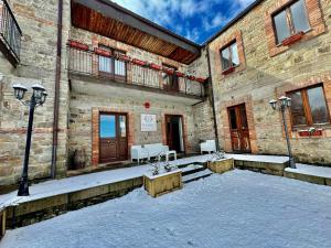 San FratelloNEBRIS - Rifugio del Parco的砖砌建筑,设有庭院,配有桌椅