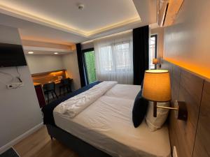 伊斯坦布尔The Blue Suites的一间卧室配有一张带台灯和桌子的床