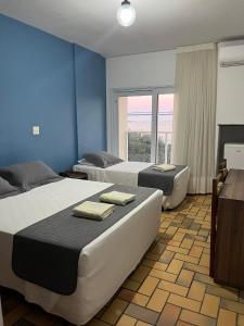 瓜拉派瑞Hotel Quatro Estações的一间卧室设有两张床和大窗户