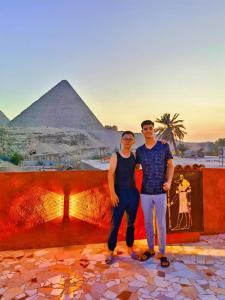 开罗Energy Of Pyramid Hotel的站在金字塔前的男人和女人