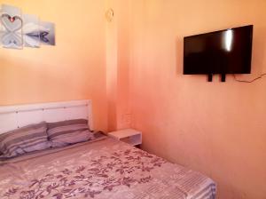 阿拉尼亚Alanya Comfort - 4 Star Beautiful Apartments between Cleopatra Beach 1 and Harbor的卧室配有一张床和壁挂式平面电视。