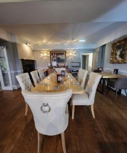 鲍内斯温德米尔The Ryebeck Classic Country House的一间带桌子和白色椅子的用餐室