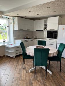 拉加希姆斯Guest house Kajaki-Ragaciems的厨房配有桌椅和白色冰箱。