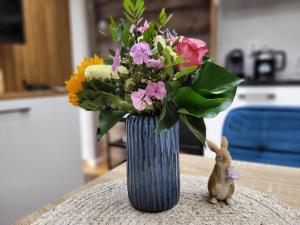 海边的艾格蒙特Tiny Villa de Haas met Infraroodsauna的花瓶,花朵盛在桌子上,有兔子
