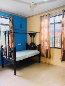 FumbaFumba House BnB的一间卧室配有一张蓝色墙壁和窗户的床
