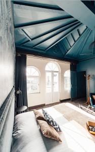 埃特勒塔La villa 10 HÔTEL SPA的一间卧室设有蓝色的天花板和一张带枕头的床。