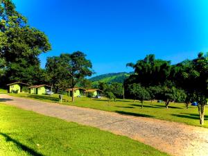卡皮托利乌Pousada e Camping Recanto da Praia的树木和房屋公园的土路
