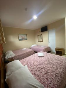 戴维Hotel Residencial Panamericano的酒店客房,配有两张带粉红色床单的床