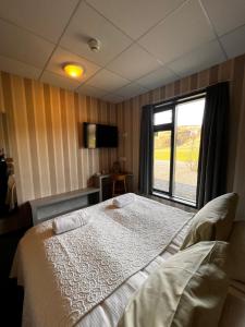斯科加尔弗斯Hótel Skógafoss by EJ Hotels的一间卧室设有一张床和一个窗口