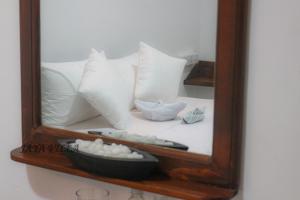 尼甘布Jaya Villa的床上的镜子和白色枕头