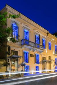 帕特雷梅森格雷科特色酒店的一座白色的大建筑,上面有蓝色的灯光