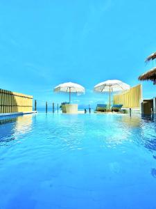 蓝梦岛伦博港和谐酒店的一个带蓝色水和遮阳伞的游泳池