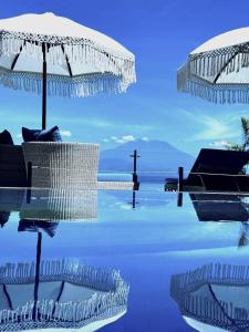 蓝梦岛伦博港和谐酒店的一个带遮阳伞和底部十字架的游泳池