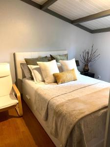 波尔图BlancoHouse. fozdodouro的一间卧室配有一张大床,提供许多枕头
