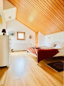 GlumslövLarge Architect designer home 800m from beach的一间设有一张床铺的卧室,位于一个拥有木制天花板的房间