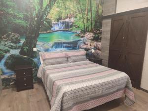托莱多Hostal El Bosque Encantado Toledo的一间卧室配有一张带瀑布壁画的床