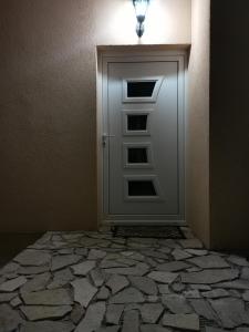 MitrovićiIn Apartments AirPort的石地板房间的门