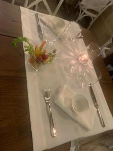 安德拉诺帕拉索美拉瓜酒店的白桌子,带眼镜和一盘食物