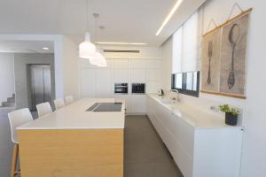 埃拉特New ! 430m Luxury Best Top Class 8-Bdr Exclusive Villa Top Design HEATED Pool Jucuzzi Sauna的一间带白色橱柜的厨房和一个带水槽的厨房岛