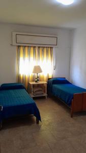 GualeguaychúMilli的一间卧室配有两张床和一张带台灯的桌子