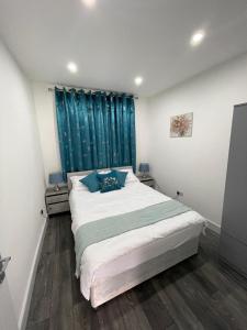 芬奇利Private One Bedroom Flat in Barnet, London的一间卧室配有一张带蓝色窗帘的大床