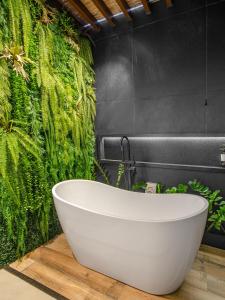 皮帕PIPA INN Pousada的带浴缸的浴室和绿色的墙壁