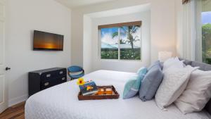 哈普那海滩MAUNA KEA SUNSETS Gorgeous 2BR Kumulani Condo with Ocean Sunset View的卧室配有一张白色床,墙上配有电视