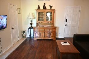 尼亚加拉瀑布Centennial Suite的客厅配有木制橱柜和桌子