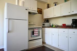 尼亚加拉瀑布Centennial Suite的厨房配有白色橱柜和白色冰箱。