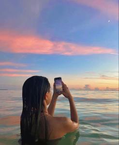 布兰卡滩Posada Shekinah Barú的水中的女人用手机拍张照片