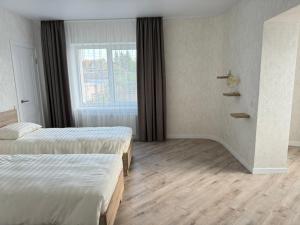 文尼察Apartments in Pyrogovo的酒店客房设有两张床和窗户。