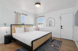 洛杉矶Aliza Hotel的白色卧室配有大床和地毯