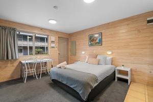 基督城Tasman Holiday Parks - Christchurch的卧室配有一张床和一张桌子及椅子