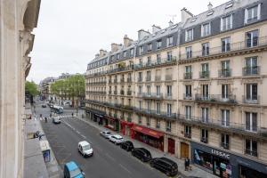 巴黎Luxury Parisian Apartment NOTRE DAME SAINT GERMAIN DES PRES的一条城市街道,汽车停在建筑前