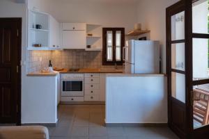 达默查理Hideaway in Damouchari with private access to sea ANNA's HORIZON的厨房配有白色橱柜和白色冰箱。
