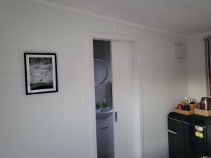 拉格伦TradeStop Short-Term Accomodation的厨房设有白色的墙壁和黑色的冰箱。