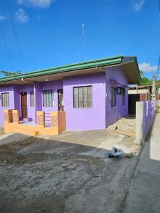 八打雁Mel's Place 2BR Apartment Unit2 in Batangas City的前面有车道的紫色房子