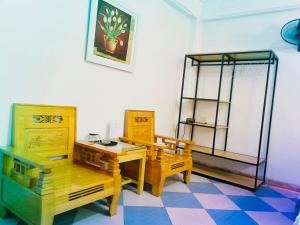 清化Thắng Lợi Hotel的配有木制家具和桌椅的客房