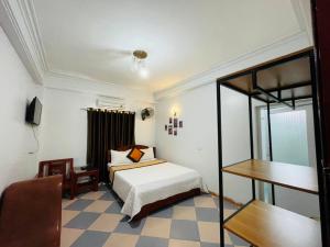 清化Thắng Lợi Hotel的一间卧室配有一张床、一张桌子和一把椅子